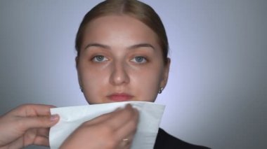 Güzellik stüdyosunda genç bir kadın için profesyonel makyaj yapıyor. Makyaj sanatçısı, modellerin yüzünü temizlemek için kağıt mendil kullanıyor