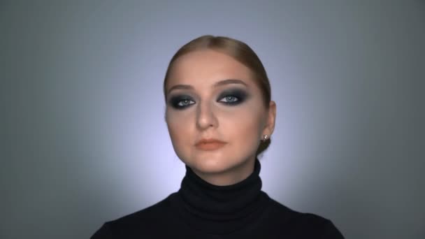 Beautiful woman with makeup smoky eyes posing at the camera — Stock Video