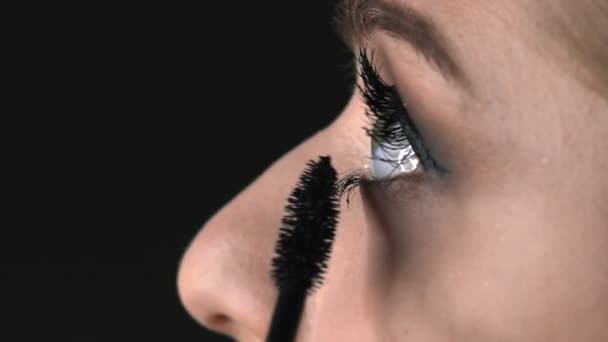 Macro shot of Makeup artist making professional make-up for young woman in beauty studio. Make up Artist uses mascara to make eyelashes — Stock Video