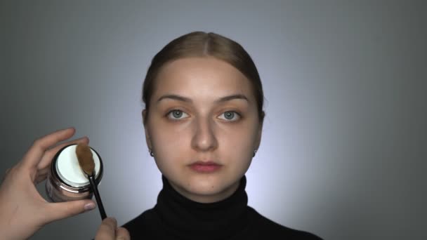 Maquillaje artista haciendo maquillaje profesional para mujer joven en el estudio de belleza. Maquillaje Artista aplica maquillaje base o imprimación. — Vídeos de Stock