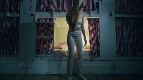 Ung flicka lägger sig i sängen och somnar i mysiga vandrarhemmet rum — Stockvideo
