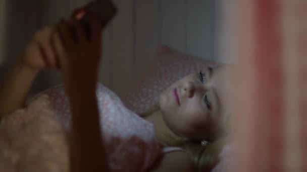 호텔 방 침대에 누워서 스마트폰을 사용하는 매력적 인 젊은 여성의 모습을 가까이 서 보 십시오 — 비디오