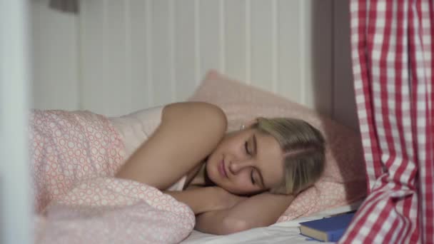 Ung kvinna sover i mysiga vandrarhemsrum — Stockvideo
