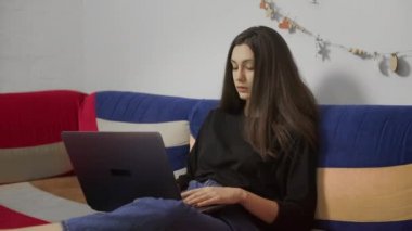 Dizüstü bilgisayarda, rahat koltukta oturan serbest çalışan bir genç. Evde dizüstü bilgisayarla çalışan serbest çalışan kadın blogcu. Blogger Gazetecisi Uzaktan Çalışıyor.