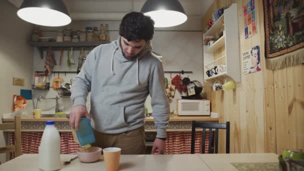 Un joven está cocinando el desayuno en la cocina — Vídeos de Stock