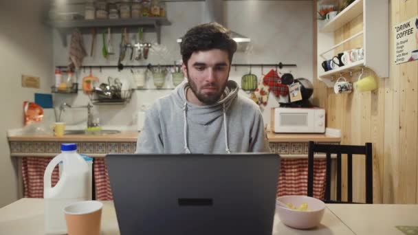 Homem de negócios trabalhando computador portátil e come flocos de milho Cereal em casa cozinha. — Vídeo de Stock