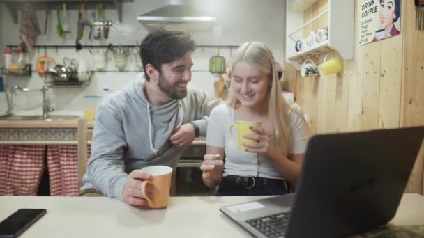 Schönes Paar plaudert und lacht beim Frühstück in der Küche — Stockvideo