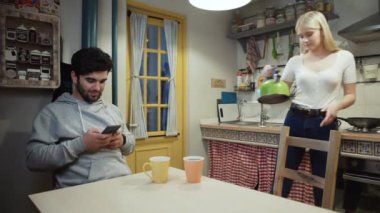 Genç çift mutfakta çay içiyor.