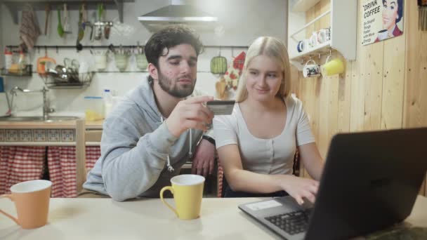 Joven hombre y mujer están haciendo una compra en línea en el cuaderno — Vídeos de Stock