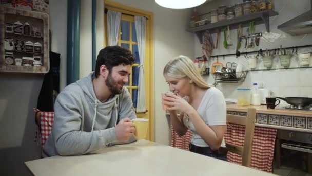 Unga par dricker te tillsammans på ett kök — Stockvideo