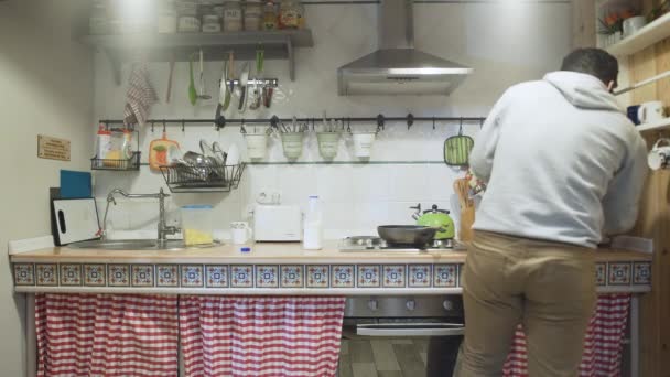 Joven viene a la cocina por la noche a tomar una leche . — Vídeos de Stock