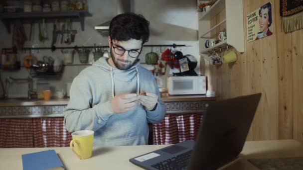 Ung man som håller sitt kreditkort om att göra en online shopping köp på bärbara datorer — Stockvideo