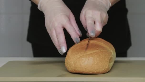 Skär färskt bröd på plastskärbräda. — Stockvideo