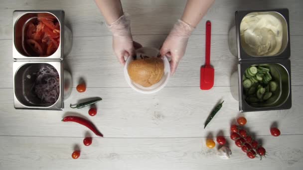 Вид зверху рук професійного шеф-кухаря в рукавичках, що роблять шаурму в хлібі — стокове відео