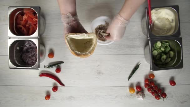 Vista superior de las manos de chef profesional en guantes haciendo shawarma en pan. Chef en guantes pone carne de pollo en shawarma — Vídeos de Stock