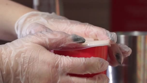 Frau in Handschuhen verschließt mit Milchshake zerschnittene Papiere und steckt Kunststoffrohr ein — Stockvideo