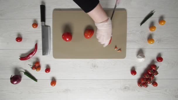 Chef coupe les tomates sur une planche de plastique vue du dessus 