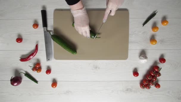 Chef coupe des concombres sur une planche de plastique vue du dessus — Video
