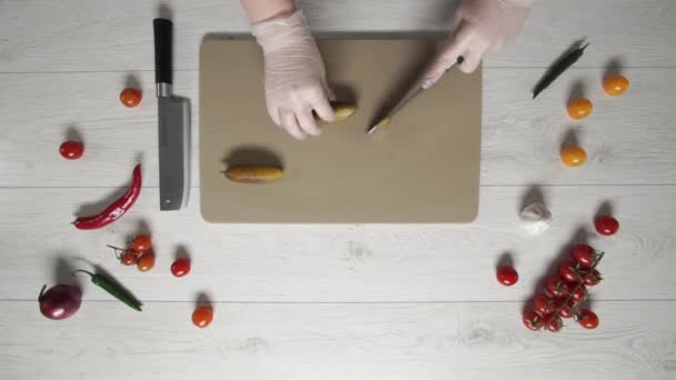 Chef schneidet gesattelte Gurken oder eingelegte Gurken auf Plastikplatte von oben — Stockvideo