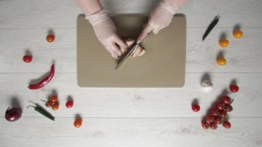 Şef tavuğu plastik tahta üstünde doğruyor.