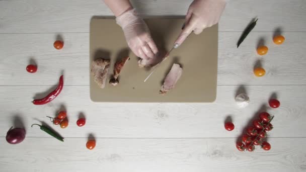 Chef cuts roast pork on plastic board top view — Stock Video