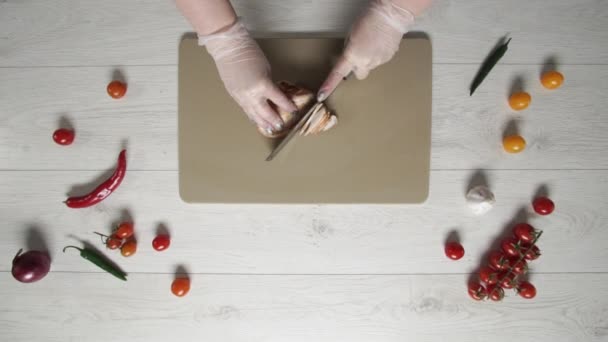 Chef coupe le poulet rôti sur une planche de plastique vue du dessus 