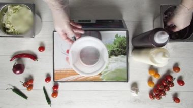 Eldivenli şef soğanı plastik kasede tartıyor.