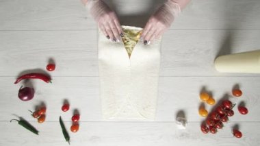 Şefin beyaz eldivenli üst görüntüsü kebapçı kebabı pide veya lavda. Tavuk, patates kızartması, peynir ve sebzeli shawarma pişiriyorum.