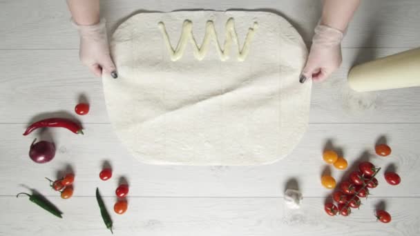 Vrchní pohled na ruce šéfkuchaře v bílých rukavicích klade pita nebo lavash na stůl. Vaření shawarma s kuřecím masem, hranolky, sýrem a zeleninou — Stock video