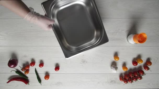 Шеф-повар в перчатках перемещает горячую и вкусную картошку фри на металлическую пластину — стоковое видео