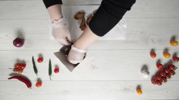 Chef puts Crispy fried chicken wings and legs in paper bag — Stock Video