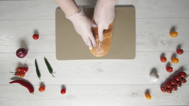 Vista dall'alto del taglio di pane fresco sul tagliere di plastica . — Video Stock