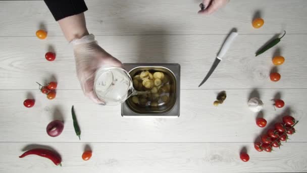 Chef verse de l'eau dans un récipient en métal avec une tranche de concombre à cornichons — Video