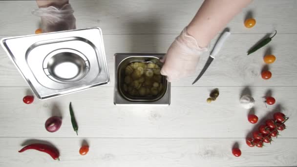 Chief neemt een paar plakjes augurken komkommers uit metalen container — Stockvideo