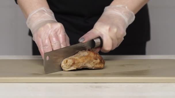 Шеф розрізає смажену свинину на пластиковій дошці — стокове відео