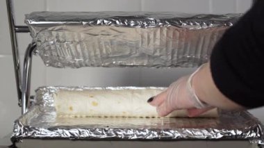 Beyaz eldivenli şef ızgaraya donör kebabı koyuyor. Tavuk, patates kızartması, peynir ve sebzeli shawarma pişiriyorum.