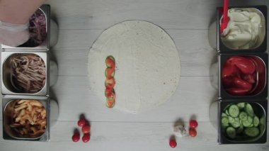 Şefin beyaz eldivenli en iyi görüntüsü, pide ya da lavda doner kebap shawarma 'nın üzerine soğan turşusu koyuyor. Tavuk, patates kızartması, peynir ve sebzeli shawarma.