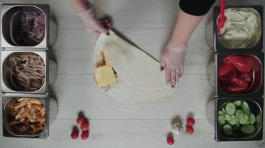 Şefin beyaz eldivenli üst görüntüsü kebapçı kebabı pide veya lavda. Tavuk, patates kızartması, peynir ve sebzeli shawarma.