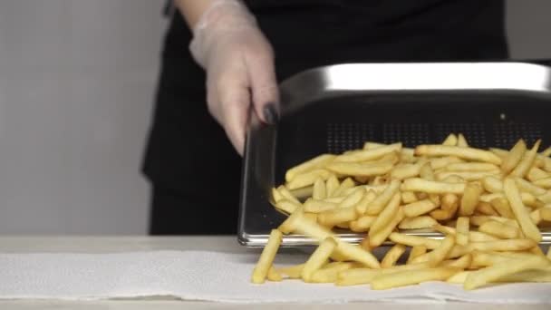 Chef em luvas remover gordura de batatas fritas quentes e deliciosos — Vídeo de Stock