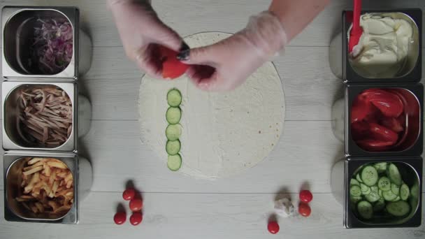 厨师们手拿着白手套的头像是把西红柿放在意大利面的烤面包片上。沙瓦玛，鸡肉，薯条，奶酪和蔬菜 — 图库视频影像