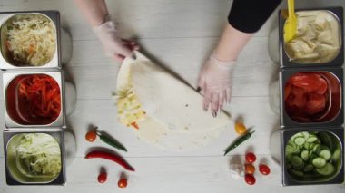 Şefin beyaz eldivenli üst görüntüsü kebapçı kebabı pide veya lavda. Tavuk pirzolası, papper, peynir ve sebzeli Shawarma.