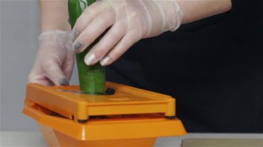 Kadın şef Grater 'da salatalık kesiyor.