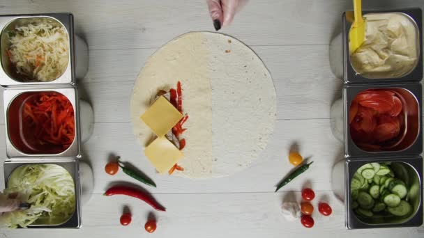 Top view of chef hands in white gloves puts cabbage on doner kebab shawarma in pita or lavash. Shawarma with chicken cutlet, pappers, cheese and vegetable — Stock Video