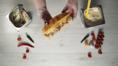 Profesyonel şef fast food restoranında lezzetli bir sandviç pişiriyor..