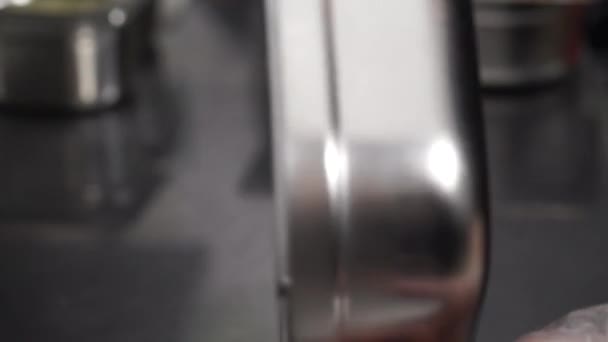 Шеф обертає металевий контейнер на кухні в ресторані — стокове відео