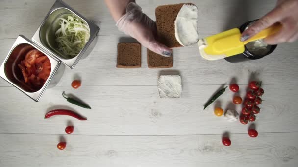 Top view of professional chef cooks a delicious burgers at fast food restaurant. Female chef in gloves puts souse on rosted breads for burgers — Stock Video