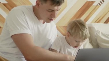 Genç babaya yaklaşmak oğlunun nasıl defter tutulacağını öğrenmesine yardımcı olur.