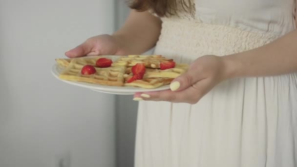 Primer plano de la familia feliz sentado alrededor de la mesa de la cocina por la mañana comiendo gofres en el desayuno juntos — Vídeo de stock