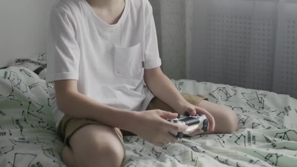 Joven concentrado pre adolescente está jugando consola de videojuegos — Vídeos de Stock