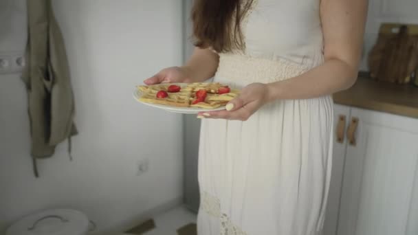 Familia feliz sentada alrededor de la mesa de la cocina por la mañana comiendo gofres en el desayuno juntos — Vídeo de stock